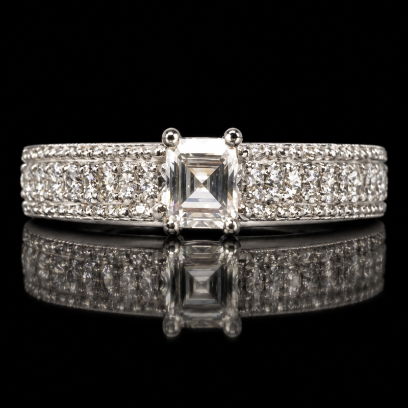 Asscher-cut diamond eternity band with a prong-set center and rows of round diamonds on a black reflective background.