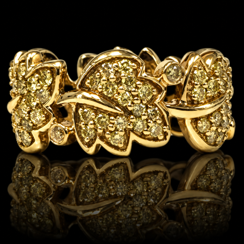 Maple leaf eternity band in 18 karat yellow gold with fancy yellow diamonds and round bezel accents, displayed on black with reflection